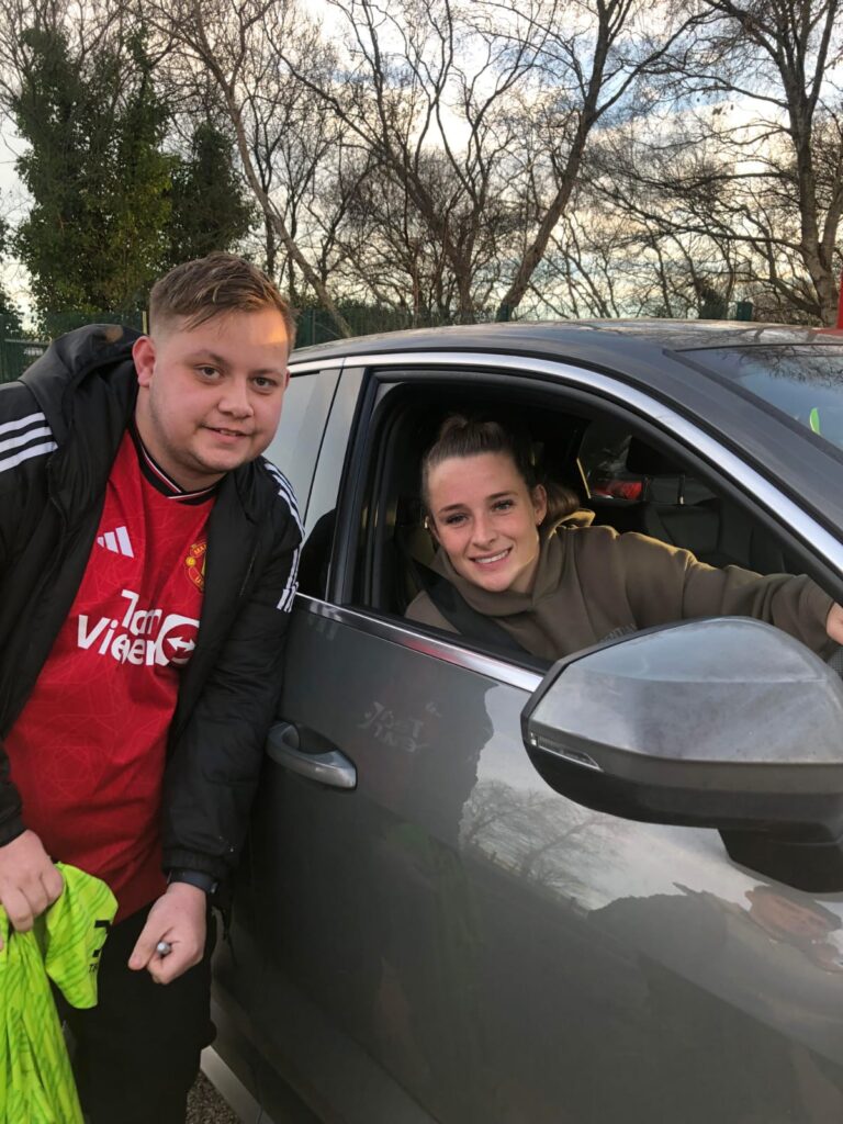 Lee with woman's football mufc player while they are in their car