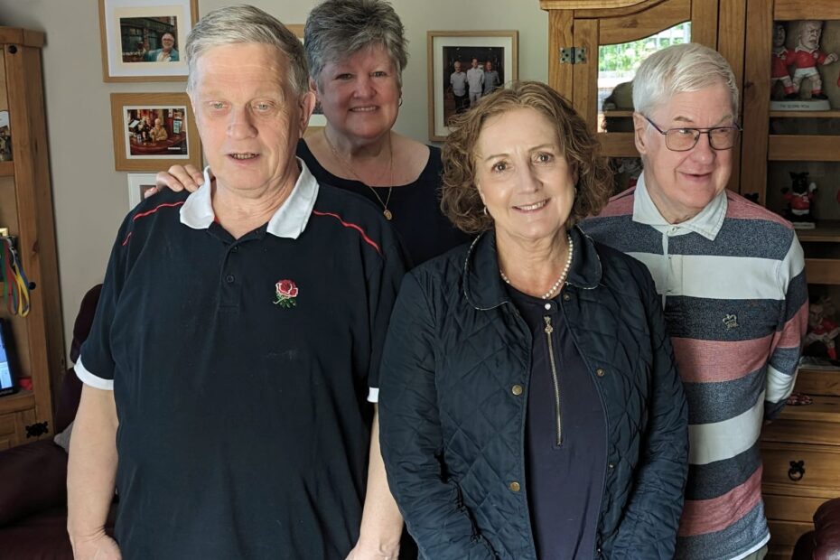 Pictured in the front room of Shared Lives carer are Medwyn and Gareth who are supported by Janet Smith pictured behind. Janet Finch Saunders MS is pictured in the foreground in between Medwyn and Gareth.