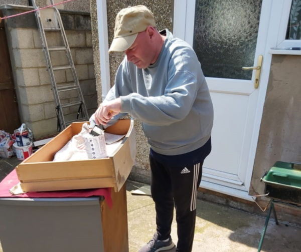 James is out in the back garden painting a chest of draws