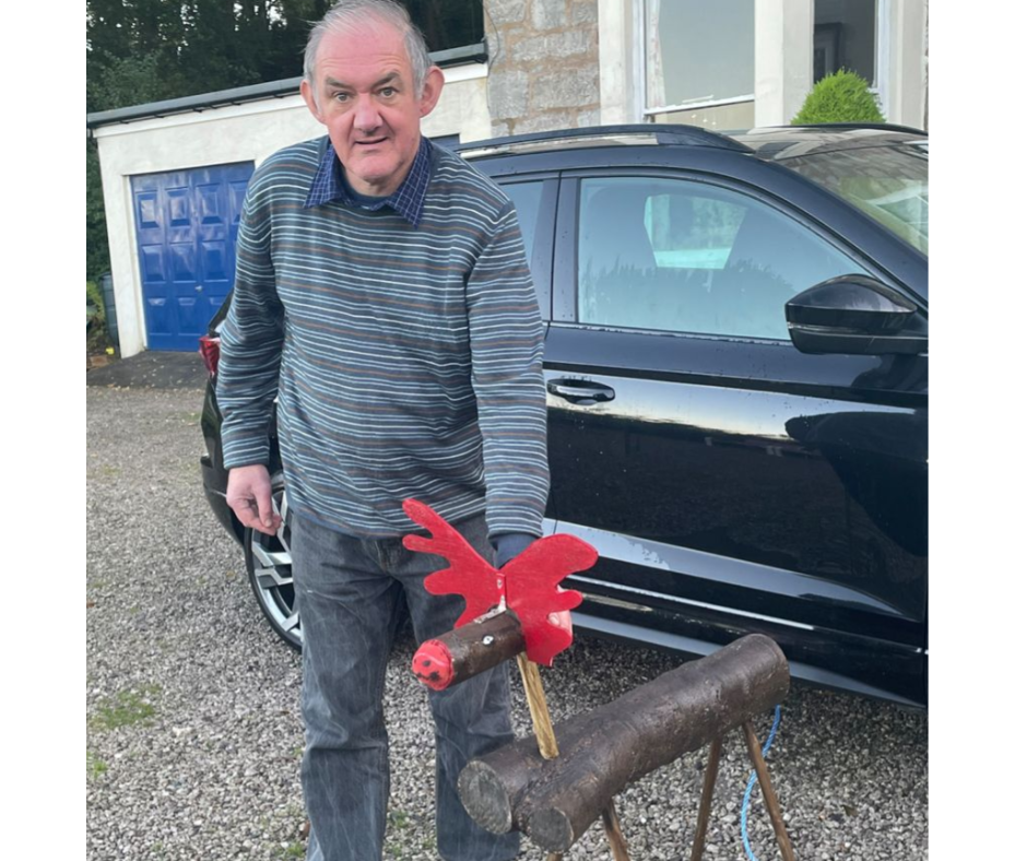 Trevor stands with his reindeer which he's even painted brown with a red nose